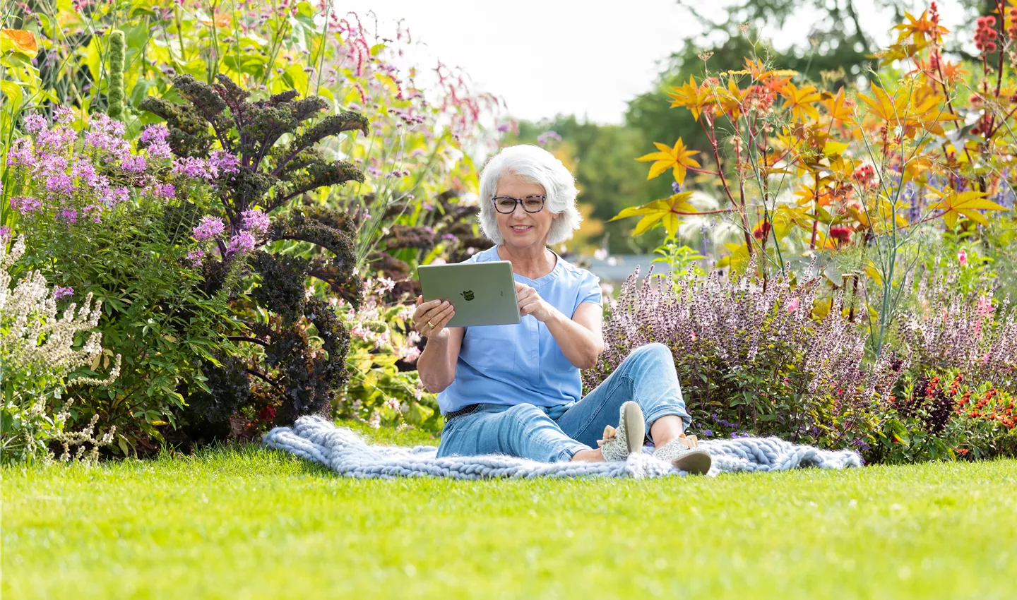 Gartenfreizeit - Frau mit Tablet im Garten