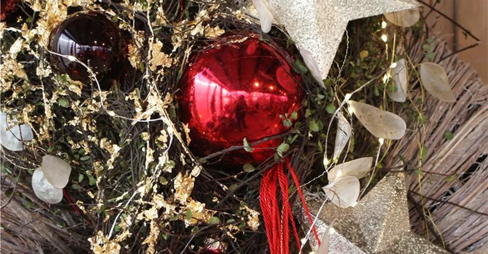 Weihnachtsschmuck mit Stern und Kugel Rote Kugel und Stern an einem Weihnachtsgesteck
