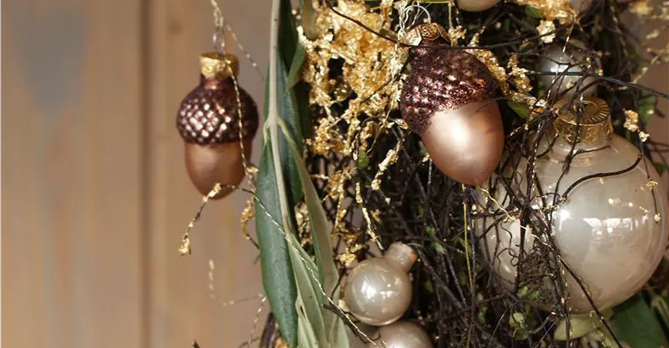 Christbaumkugeln in Gold und Champagner Goldene und champagnerfarbene Christbaumkugeln mit Zweigen